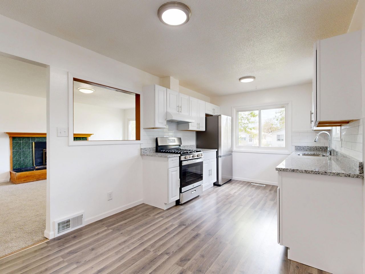 our-values Bright, newly renovated kitchen featuring white cabinets, hardwood floors, and stainless steel appliances.