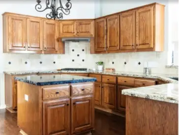 L-shaped kitchen with warm wooden cabinets, granite countertops, and a central island.